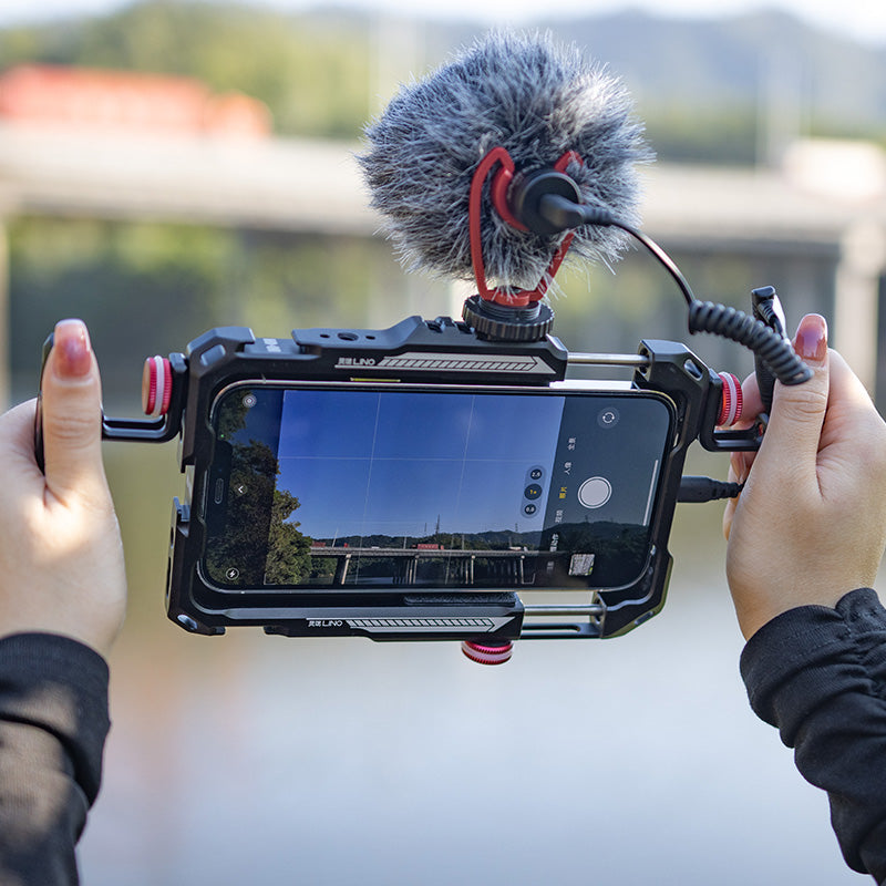 Ulanzi Lino Smartphone Rig with Microphone - filming outdoors with black and red metal rig.